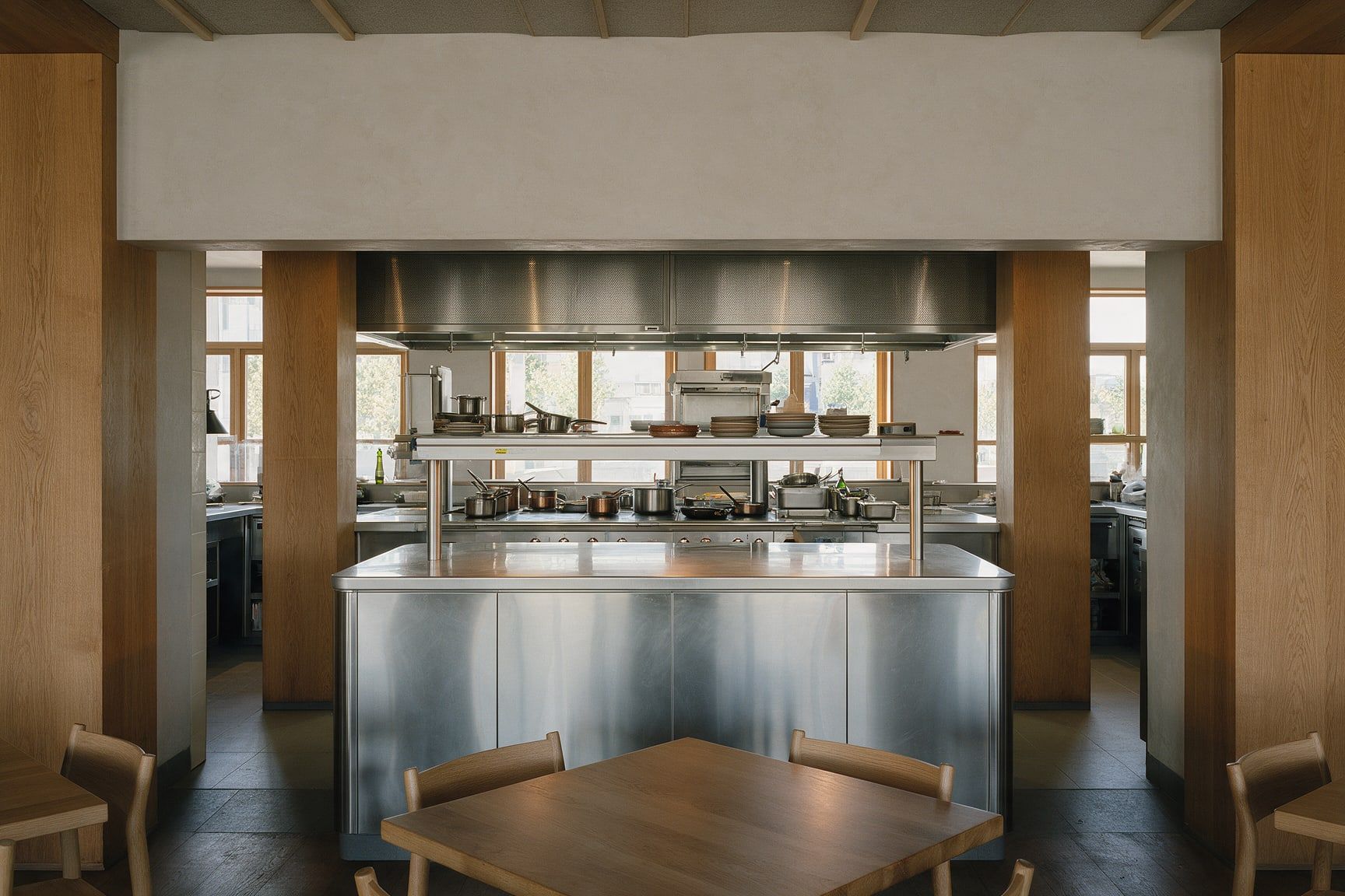 Cocina abierta de restaurante con barra de pase en acero inoxidable, imagen conceptual.